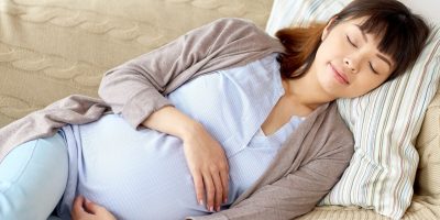 Gravid kvinna sover på soffan